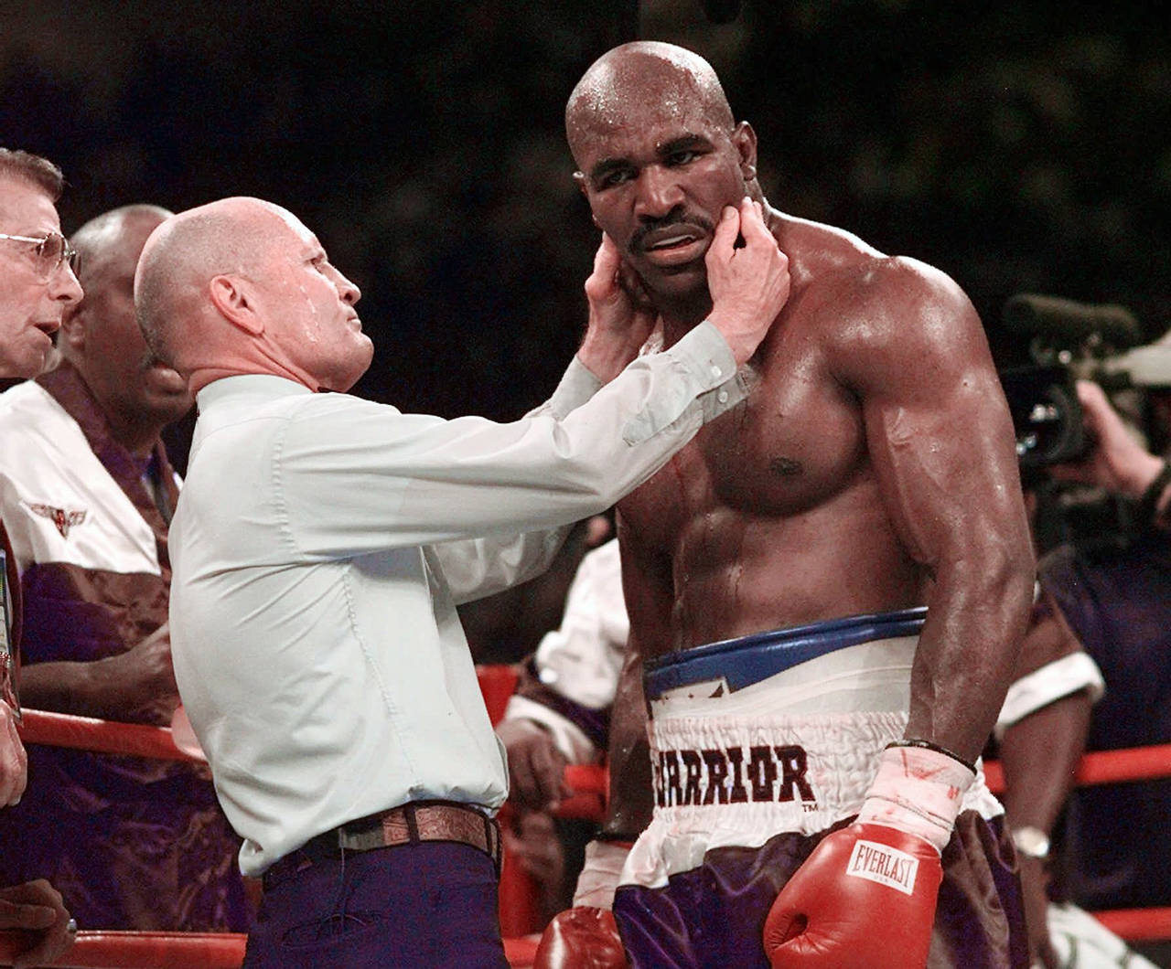 FILE - Evander Holyfield has his right ear checked by referee Mills Lane after he was bit on the ea...