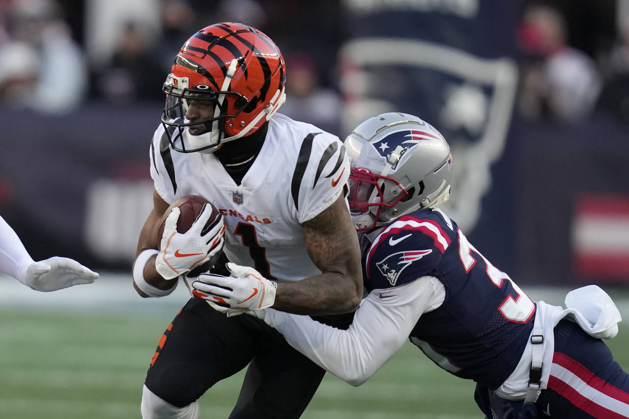 Cincinnati Bengals wide receiver Ja'Marr Chase (1) is brought down by New England Patriots cornerba...