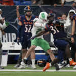 
              UTSA running back Kevorian Barnes (31) is grabbed by North Texas linebacker Sean-Thomas Faulkner (25) during the second half of an NCAA college football game for the Conference USA championship in San Antonio, Friday, Dec. 2, 2022. (AP Photo/Eric Gay)
            