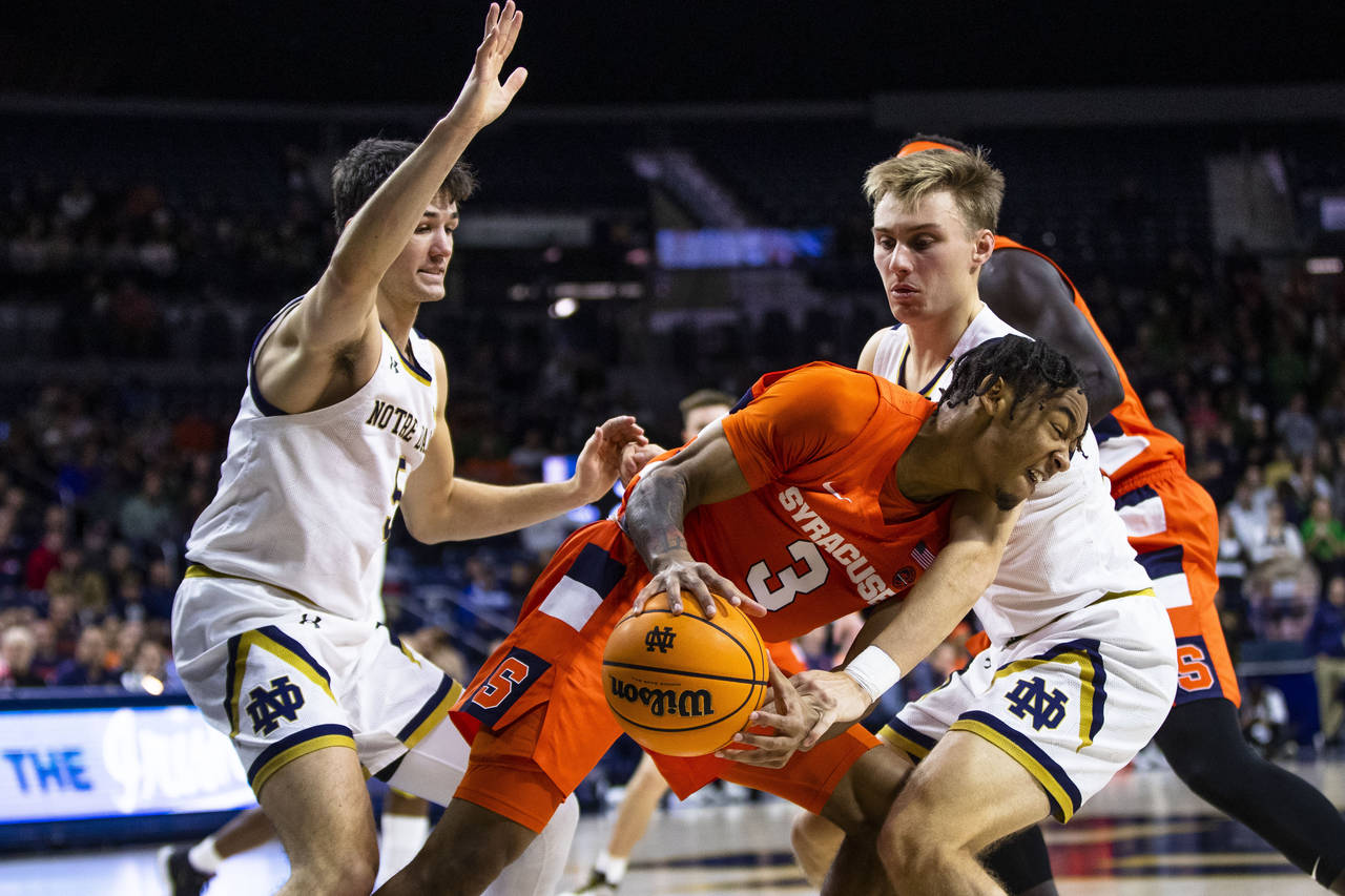 Syracuse's Judah Mintz (3) tries to get around as Notre Dame's Dane Goodwin, right, and Cormac Ryan...
