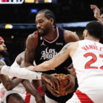 
              Los Angeles Clippers forward Kawhi Leonard tries to keep the ball from Toronto Raptors guard Gary Trent Jr., left, and guard Fred VanVleet (23) during the first half of an NBA basketball game Tuesday, Dec. 27, 2022, in Toronto. (Frank Gunn/The Canadian Press via AP)
            