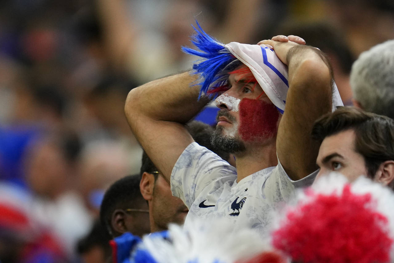 A fan of France holds his head at the end of the World Cup final soccer match between Argentina and...