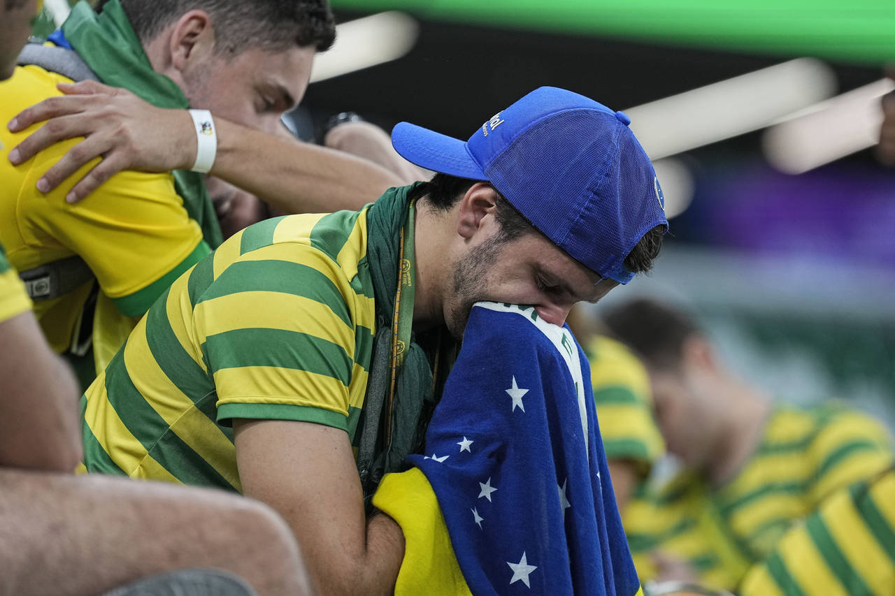 Brazilian fans react on the tribune after losing the World Cup quarterfinal soccer match between Cr...