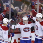 
              Montreal Canadiens' Cole Caufield, center, celebrates his goal against the Calgary Flames with Mike Matheson, left, and Kirby Dach during third period of an NHL hockey game in Calgary, Alberta, Thursday, Dec. 1, 2022. (Larry MacDougal/The Canadian Press via AP)
            