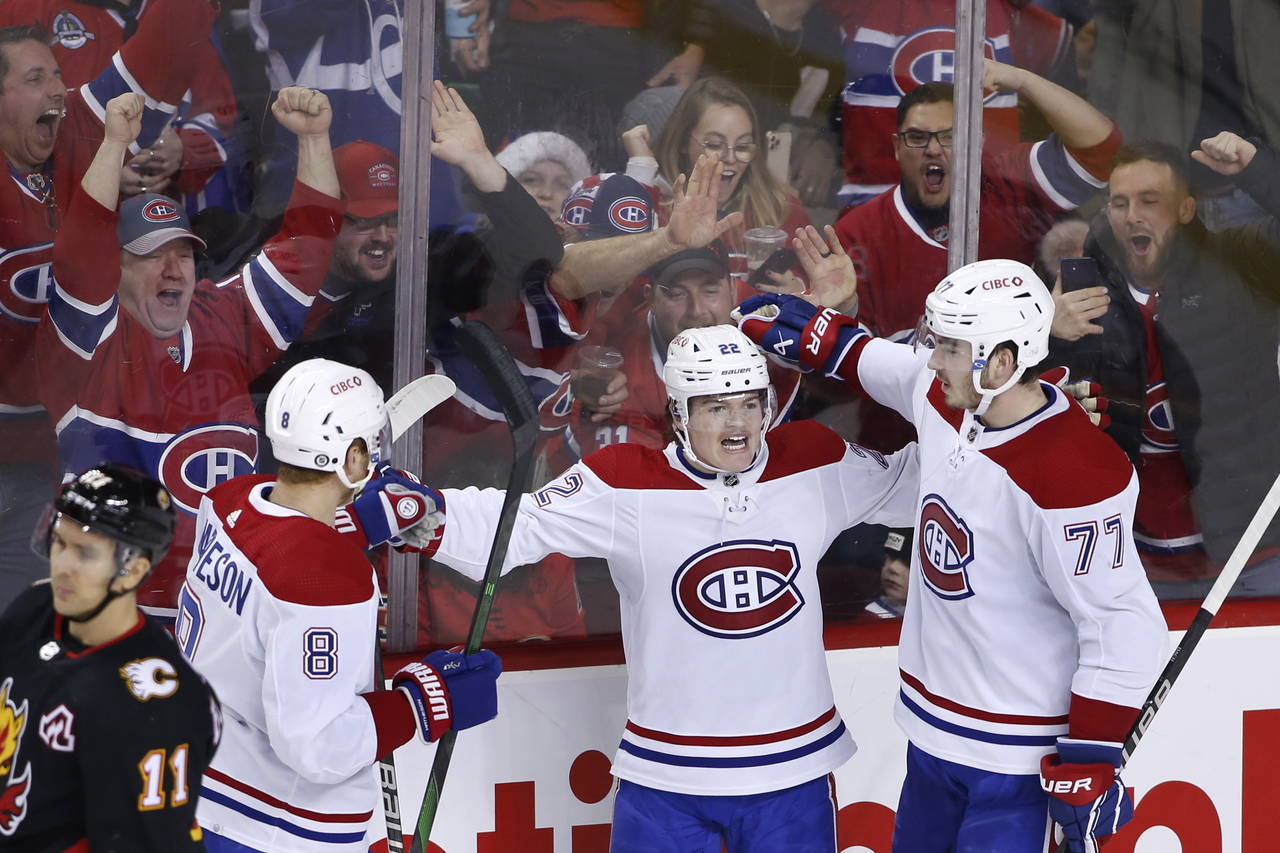 Montreal Canadiens' Cole Caufield, center, celebrates his goal against the Calgary Flames with Mike...