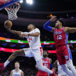 
              Los Angeles Clippers' Norman Powell, left, goes up for a shot past Philadelphia 76ers' Tobias Harris during the first half of an NBA basketball game, Friday, Dec. 23, 2022, in Philadelphia. (AP Photo/Matt Slocum)
            