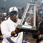 
              Jackson State head coach Deion Sanders hoists the winner's trophy following the Southwestern Athletic Conference championship NCAA college football game against Southern University, Saturday, Dec. 3, 2022, in Jackson, Miss. Jackson State won 43-24. (AP Photo/Rogelio V. Solis)
            