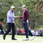 
              Mike Thomas, center left, and Justin Thomas, center right, fist bump after Mike's putt on the 3rd hole during the final round of the PNC Championship golf tournament Sunday, Dec. 18, 2022, in Orlando, Fla. Charlie Woods, left, lines up a putt as Tiger Woods, right, watches. (AP Photo/Kevin Kolczynski)
            