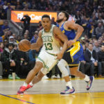 
              Boston Celtics guard Malcolm Brogdon (13) drives to the basket against Golden State Warriors guard Stephen Curry during the first half of an NBA basketball game in San Francisco, Saturday, Dec. 10, 2022. (AP Photo/Godofredo A. Vásquez)
            