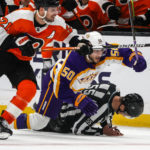 
              Los Angeles Kings defenseman Sean Durzi, center, crashes with referee Kyle Flemington, right, during the third period of an NHL hockey game against the Philadelphia Flyers Saturday, Dec. 31, 2022, in Los Angeles. The Philadelphia Flyers won 4-2. (AP Photo/Ringo H.W. Chiu)
            