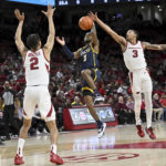 
              UNC Greensboro guard Kobe Langley (3) tries to drive past Arkansas defenders Trevon Brazile (2) and Nick Smith Jr. (3) during the first half of an NCAA college basketball game Tuesday, Dec. 6, 2022, in Fayetteville, Ark. (AP Photo/Michael Woods)
            