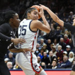 
              Connecticut's Azzi Fudd (35) is pressured by Providence's Janai Crooms, left, and Kylee Sheppard, right, in the first half of an NCAA college basketball game, Friday, Dec. 2, 2022, in Storrs, Conn. (AP Photo/Jessica Hill)
            