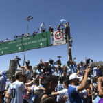 
              Argentine soccer fans climb on highway signs for a homecoming parade for the Argentine soccer team that won the World Cup tournament in Buenos Aires, Argentina, Tuesday, Dec. 20, 2022. (AP Photo/Mario De Fina)
            