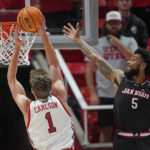 
              Utah forward Ben Carlson (1) goes to the basket as Jacksonville State guard Skyelar Potter (5) defends during the first half of an NCAA college basketball game Thursday, Dec. 8, 2022, in Salt Lake City. (AP Photo/Rick Bowmer)
            