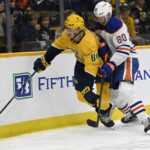 
              Nashville Predators left wing Tanner Jeannot (84) reaches for the puck as Edmonton Oilers left wing Markus Niemelainen (80) defends during the second period of an NHL hockey game Monday, Dec. 19, 2022, in Nashville, Tenn. (AP Photo/Mark Zaleski)
            