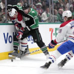 
              Montreal Canadiens' Juraj Slafkovsky, left, is checked against the boards by Dallas Stars defenseman Ryan Suter, second from left, as they and Christian Dvorak (28) compete for control of the puck in the second period of an NHL hockey game, Friday, Dec. 23, 2022, in Dallas. (AP Photo/Tony Gutierrez)
            