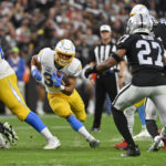 
              Los Angeles Chargers running back Austin Ekeler (30) carries for a first down during the first half of an NFL football game against the Las Vegas Raiders, Sunday, Dec. 4, 2022, in Las Vegas. (AP Photo/David Becker)
            
