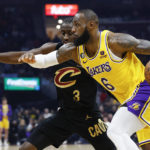 
              Los Angeles Lakers forward LeBron James (6) drives against Cleveland Cavaliers guard Caris LeVert (3) during the first half of an NBA basketball game Tuesday, Dec. 6, 2022, in Cleveland. (AP Photo/Ron Schwane)
            