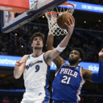 
              Washington Wizards forward Deni Avdija (9) goes to the basket against Philadelphia 76ers center Joel Embiid (21) during the first half of an NBA basketball game, Tuesday, Dec. 27, 2022, in Washington. (AP Photo/Nick Wass)
            
