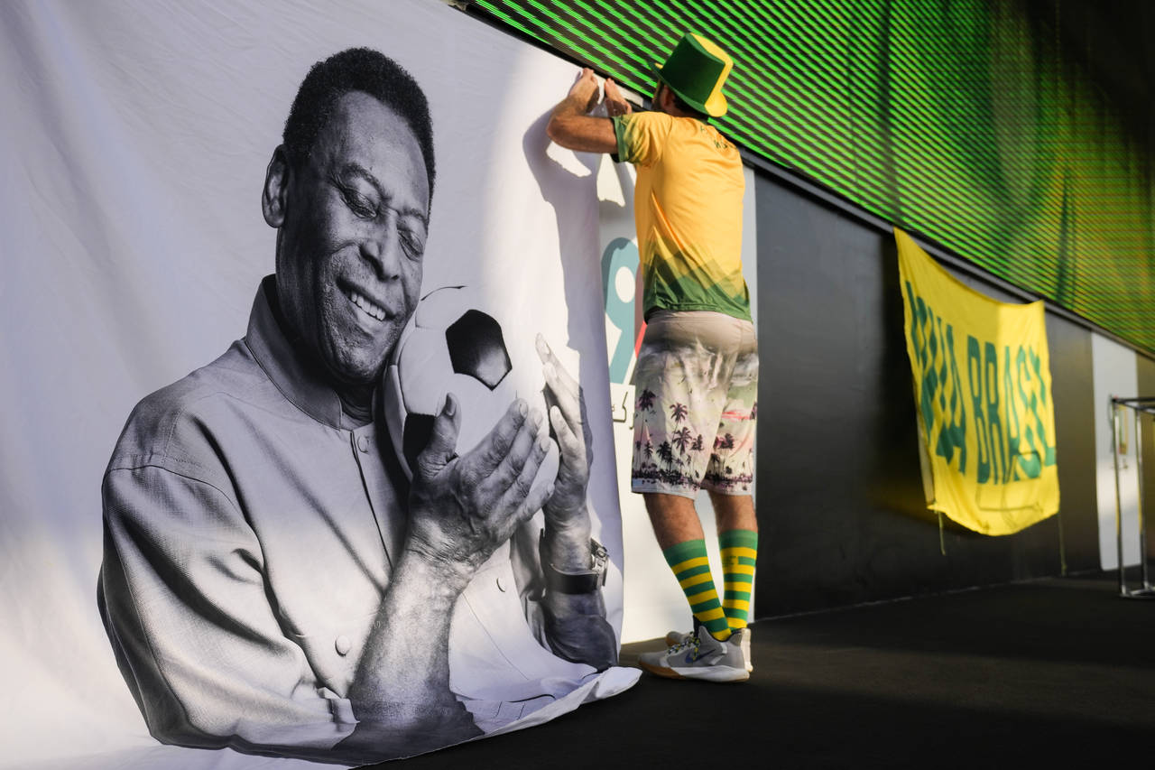 A fan displays a sign in support of Pelé at a Brazilian fan party before the the World Cup round o...