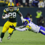 
              Green Bay Packers running back AJ Dillon (28) is tackled after a catch by Los angles Rams cornerback Jalen Ramsey (5) in the first half of an NFL football game in Green Bay, Wis. Monday, Dec. 19, 2022. (AP Photo/Matt Ludtke)
            