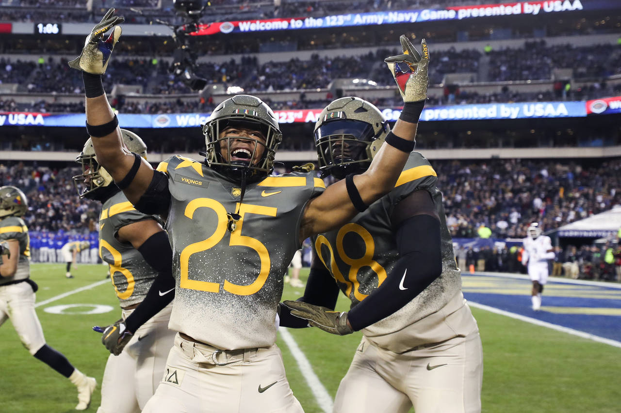 Army players celebrate after the team blocked a punt return by Navy for a touchdown in the second q...