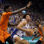 
              Kansas forward Jalen Wilson, center is pressured by Oklahoma State forward Kalib Boone, left during the first half of an NCAA college basketball game Saturday, Dec. 31, 2022, in Lawrence, Kan. (AP Photo/Charlie Riedel)
            