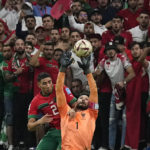 
              France's goalkeeper Hugo Lloris and Morocco's Achraf Hakimi challenge for the ball in front of Morocco's supporters during the World Cup semifinal soccer match between France and Morocco at the Al Bayt Stadium in Al Khor, Qatar, Wednesday, Dec. 14, 2022. (AP Photo/Martin Meissner)
            