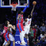 
              Los Angeles Clippers' Paul George, right, tries to get a shot past Philadelphia 76ers' Joel Embiid during the second half of an NBA basketball game, Friday, Dec. 23, 2022, in Philadelphia. (AP Photo/Matt Slocum)
            
