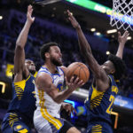 
              Golden State Warriors guard Stephen Curry (30) attempts a shot between Indiana Pacers center Myles Turner (33) and forward Aaron Nesmith (23) during the first half of an NBA basketball game in Indianapolis, Wednesday, Dec. 14, 2022. (AP Photo/Michael Conroy)
            