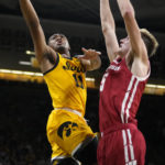 
              Iowa guard Tony Perkins (11) drives to the basket past Wisconsin forward Tyler Wahl (5) during the second half of an NCAA college basketball game, Sunday, Dec. 11, 2022, in Iowa City, Iowa. (AP Photo/Charlie Neibergall)
            