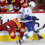 
              Calgary Flames' Dillon Dube, left, is knocked off the puck and sent headfirst into the boards by Vancouver Canucks' William Lockwood during the second period of an NHL hockey game Saturday, Dec. 31, 2022, in Calgary, Alberta. (Larry MacDougal/The Canadian Press via AP)
            