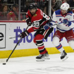 
              New York Rangers left wing Artemi Panarin (10) defends against Chicago Blackhawks center Andreas Athanasiou (89) during the second period of an NHL hockey game Sunday, Dec. 18, 2022, in Chicago. (AP Photo/David Banks)
            