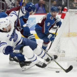 
              Toronto Maple Leafs center Alexander Kerfoot tumbles to the ice while fighting for control of the puck against Colorado Avalanche defenseman Erik Johnson during the second period of an NHL hockey game Saturday, Dec. 31, 2022, in Denver. (AP Photo/David Zalubowski)
            