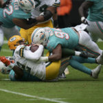 
              Green Bay Packers quarterback Aaron Rodgers (12) gets sacked by Miami Dolphins defensive tackle Christian Wilkins (94), and Miami Dolphins safety Eric Rowe (21), bottom, during the first half of an NFL football game, Sunday, Dec. 25, 2022, in Miami Gardens, Fla. (AP Photo/Jim Rassol)
            