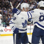 
              Toronto Maple Leafs left wing Michael Bunting, front left, is congratulated after scoring a goal by right wing William Nylander in the second period of an NHL hockey game against the Colorado Avalanche, Saturday, Dec. 31, 2022, in Denver. (AP Photo/David Zalubowski)
            