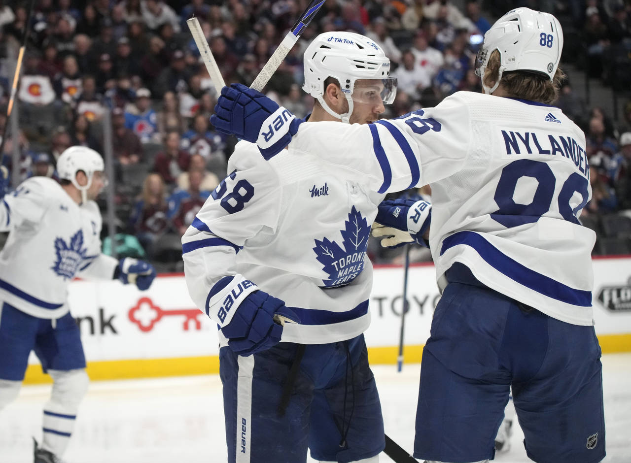 Toronto Maple Leafs left wing Michael Bunting, front left, is congratulated after scoring a goal by...