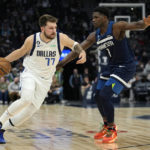 
              Dallas Mavericks guard Luka Doncic (77) works towards the basket against Minnesota Timberwolves guard Anthony Edwards (1) during the second half of an NBA basketball game, Wednesday, Dec. 21, 2022, in Minneapolis. (AP Photo/Abbie Parr)
            