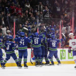 
              Vancouver Canucks players celebrate Elias Pettersson's winning goal against the Montreal Canadiens during overtime of an NHL hockey game in Vancouver, British Columbia, Monday, Dec. 5, 2022. (Darryl Dyck/The Canadian Press via AP)
            