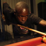 
              Levite Chisakarire, 18 years old, plays pool on the outskirts of Harare, Zimbabwe, Saturday. Nov, 19, 2022. Unable to further his education after finishing high school with low grades in 2019, Chisakarire struggled to find a job in Zimbabwe's stressed industries. Previously a minority and elite sport in Zimbabwe, the game has increased in popularity over the years, first as a pastime and now as a survival mode for many in a country where employment is hard to come by. (AP Photo/Tsvangirayi Mukwazhi)
            