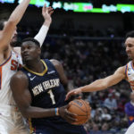 
              New Orleans Pelicans forward Zion Williamson (1) drives to the basket between Phoenix Suns forward Dario Saric and guard Damion Lee (10) in the second half of an NBA basketball game in New Orleans, Sunday, Dec. 11, 2022. The Pelicans won 129-124. (AP Photo/Gerald Herbert)
            
