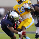 
              Southern University running back Karl Ligon (19) spins out of the grasp of Jackson State safety Cam'Ron Silmon-Craig (7) during the first half of the Southwestern Athletic Conference championship NCAA college football game Saturday, Dec. 3, 2022, in Jackson, Miss. (AP Photo/Rogelio V. Solis)
            