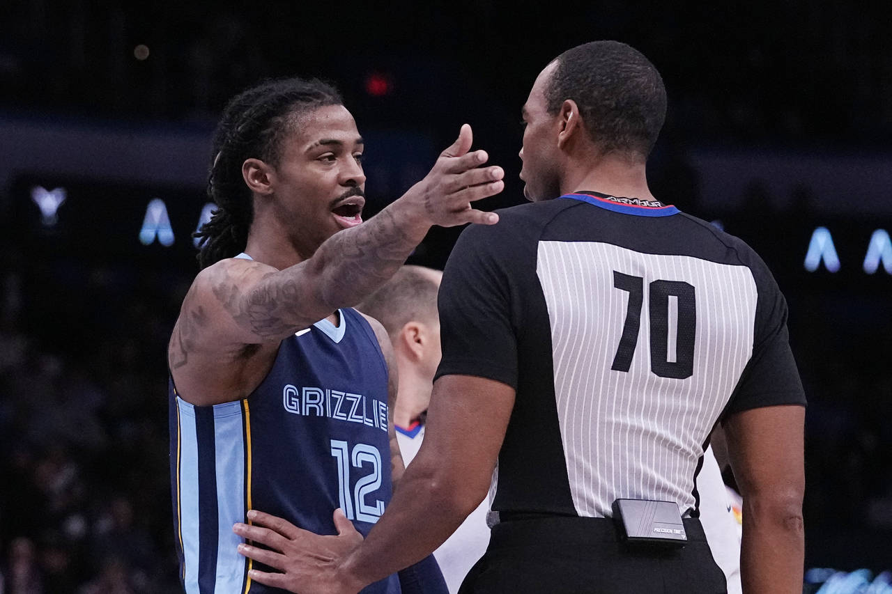 Memphis Grizzlies guard Ja Morant (12) talks to referee Phenizee Ransom, right, after receiving a t...