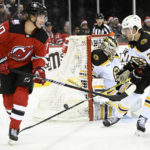 
              New Jersey Devils center Jesper Boqvist (70) and Boston Bruins defenseman Brandon Carlo (25) attempt to control the puck as Bruins goaltender Linus Ullmark (35) protects the net during the second period of an NHL hockey game Friday, Dec. 23, 2022, in Newark, N.J. (AP Photo/Bill Kostroun)
            