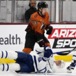 
              Arizona Coyotes left wing Michael Carcone (53) sends Toronto Maple Leafs defenseman Justin Holl (3) to the ice during the first period of an NHL hockey game in Tempe, Ariz., Thursday, Dec. 29, 2022. (AP Photo/Ross D. Franklin)
            