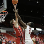 
              Utah center Branden Carlson, left, blocks a shot by Washington State guard TJ Bamba during the second half of an NCAA college basketball game, Sunday, Dec. 4, 2022, in Pullman, Wash. Utah won 67-65. (AP Photo/Young Kwak)
            