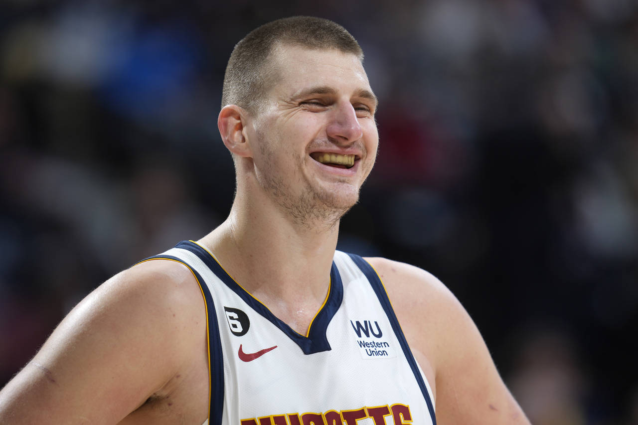 Denver Nuggets center Nikola Jokic jokes with teammates late in the second half of an NBA basketbal...