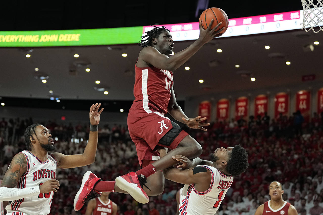 Alabama center Charles Bediako (14) is fouled by Houston guard Jamal Shead (1), right, during the f...