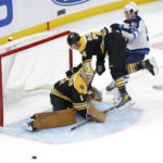 
              Boston Bruins goaltender Jeremy Swayman (1) watches the puck after making a save as Jake DeBrusk (74) crashes into the goal next to Winnipeg Jets center Cole Perfetti (91) during the third period of an NHL hockey game, Thursday, Dec. 22, 2022, in Boston. (AP Photo/Mary Schwalm)
            