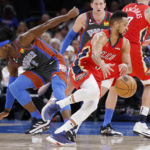 
              New Orleans Pelicans guard CJ McCollum, front right, drives the ball away from Oklahoma City Thunder guard Luguentz Dort (5) during the first half of an NBA basketball game Friday, Dec. 23, 2022, in Oklahoma City. (AP Photo/Garett Fisbeck)
            